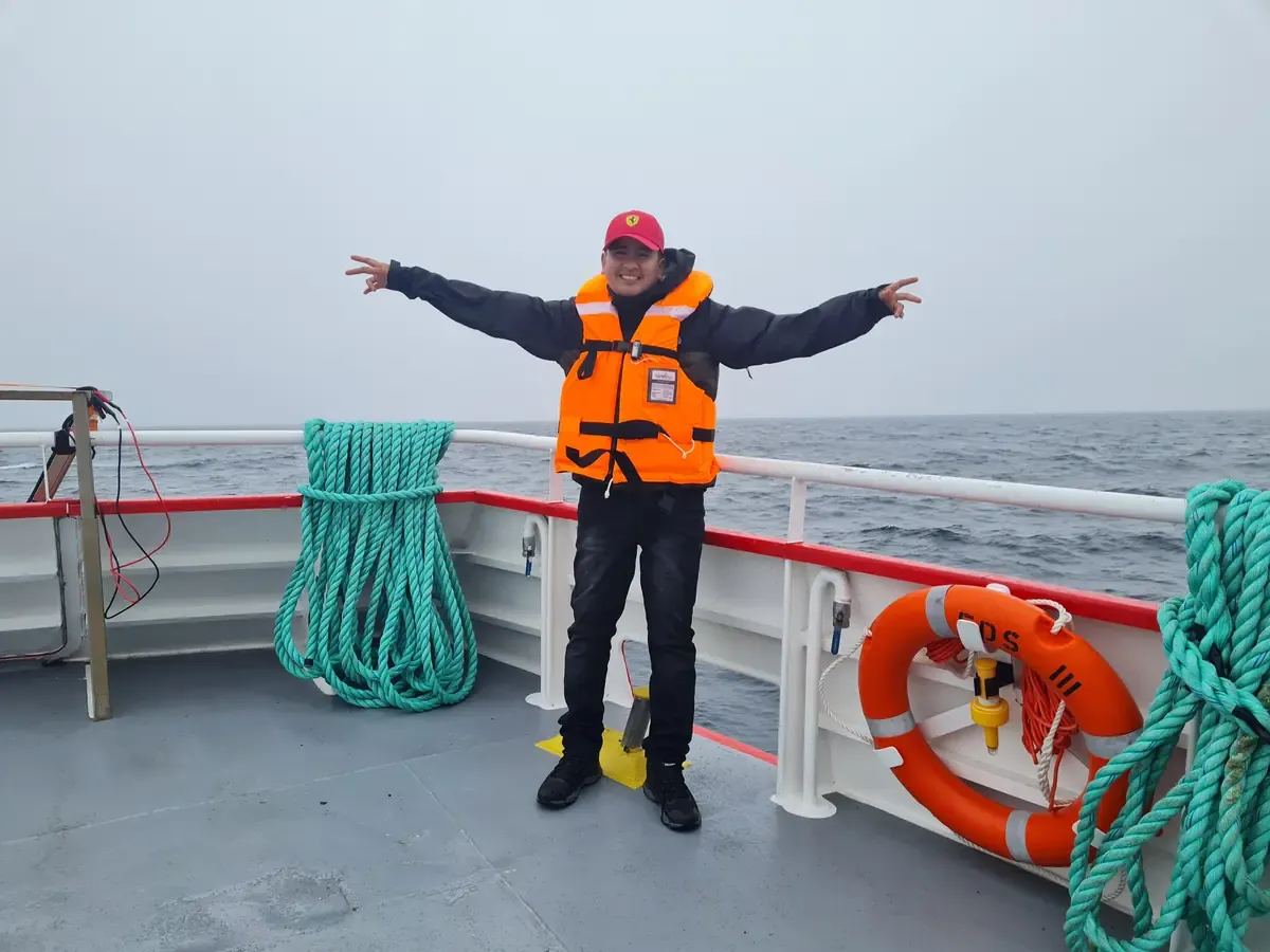 Traveler wearing an orange life jacket on a boat deck during the excursion to Magdalena Island