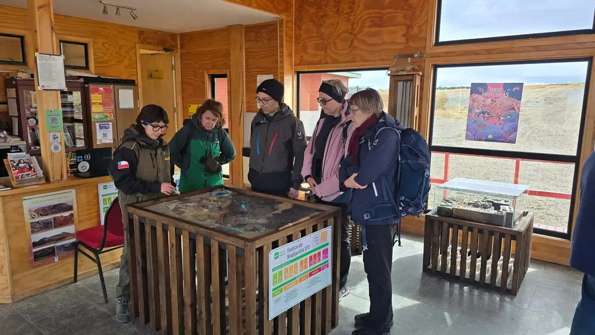 Park ranger explaining the park's relief model to visitors at the Pali Aike information center.